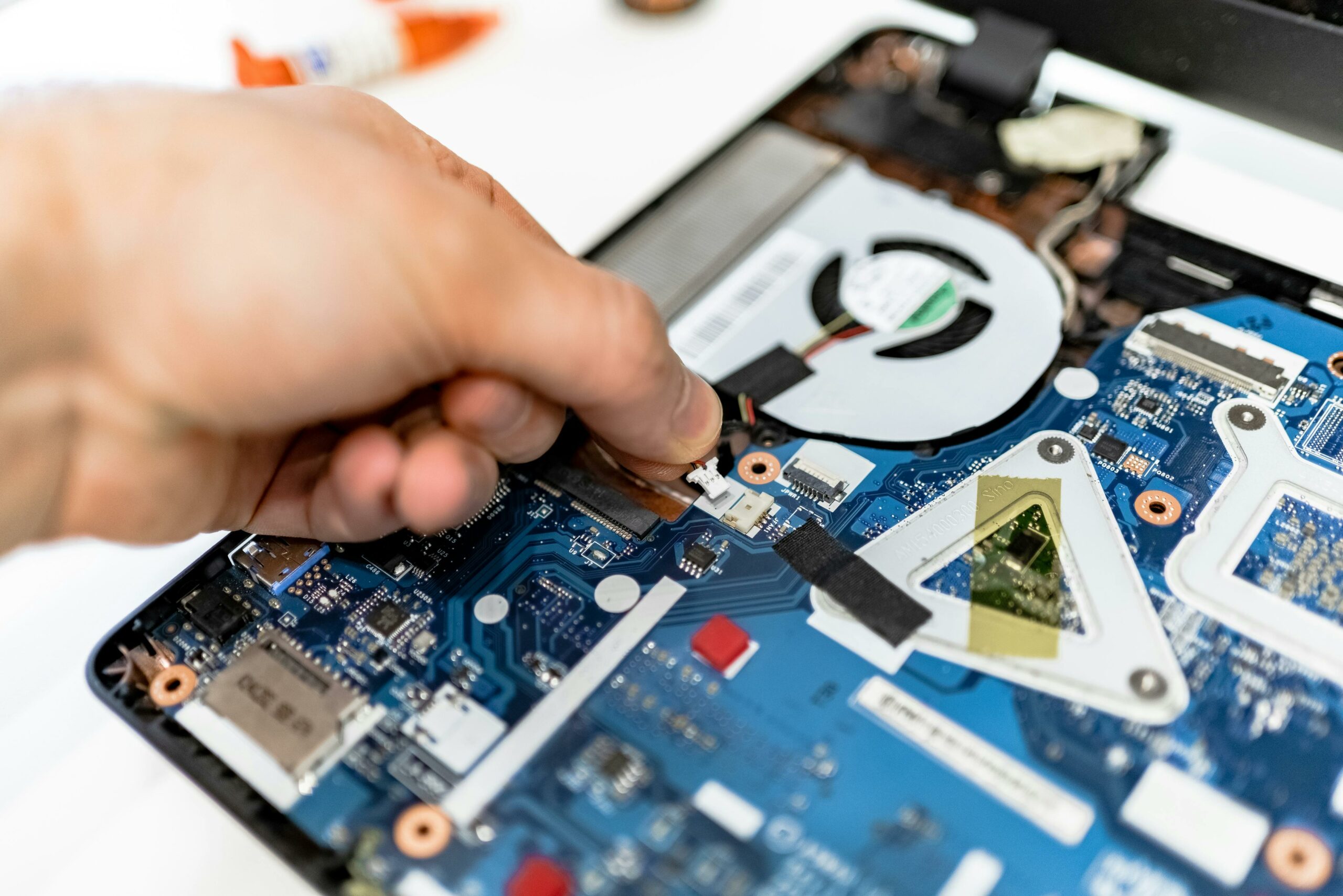 A mechanic fixing the internal chip of a laptop